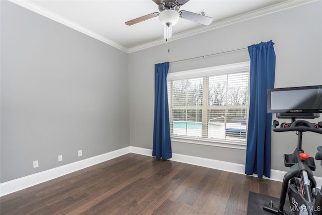 workout area with ceiling fan, dark wood-type flooring, and ornamental molding