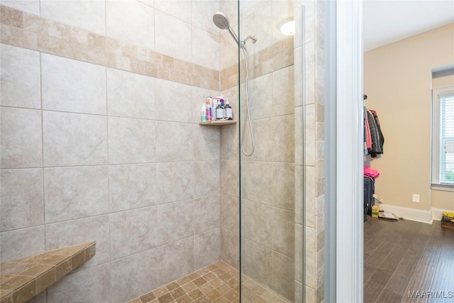 bathroom featuring hardwood / wood-style flooring and tiled shower