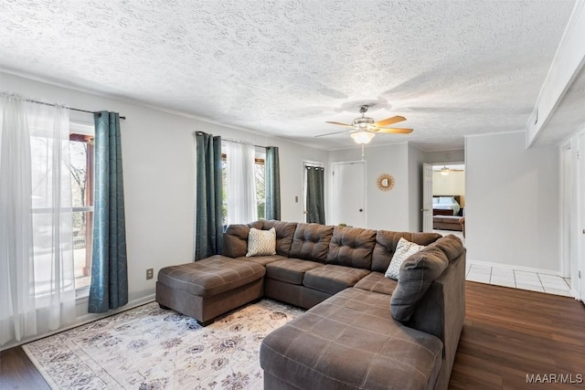 living room featuring ceiling fan, hardwood / wood-style floors, a textured ceiling, and a healthy amount of sunlight