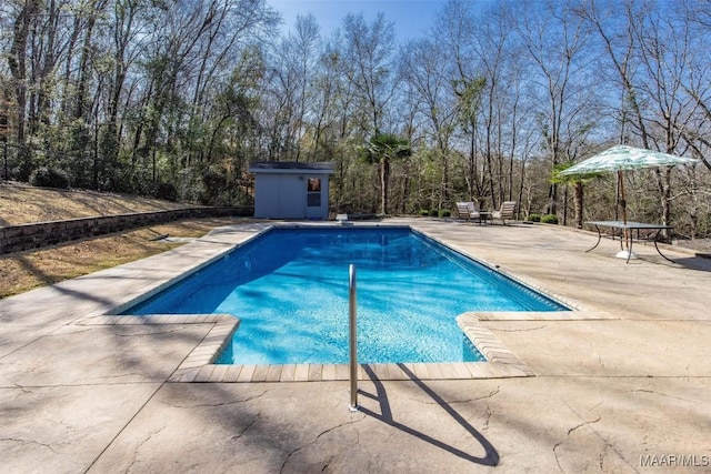 view of pool featuring a patio area and a storage shed