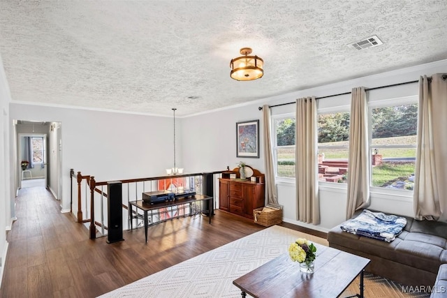 living room featuring crown molding, dark hardwood / wood-style floors, and a textured ceiling