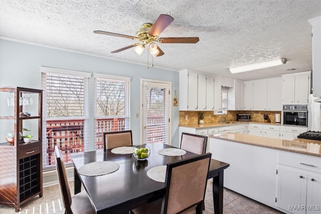 kitchen featuring a textured ceiling, black oven, white cabinets, and tasteful backsplash