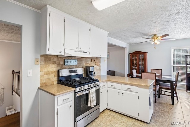 kitchen featuring decorative backsplash, kitchen peninsula, white cabinetry, and stainless steel gas range