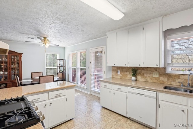 kitchen with sink, backsplash, white cabinetry, and white dishwasher