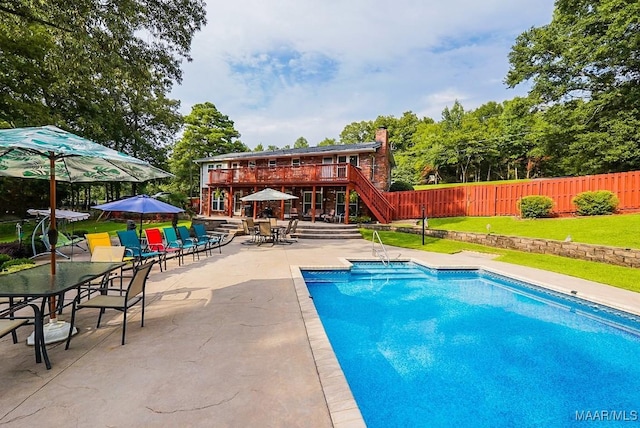 view of swimming pool with a patio, a wooden deck, and a yard