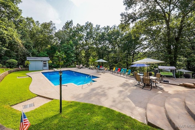 view of swimming pool with a storage unit, a yard, and a patio area