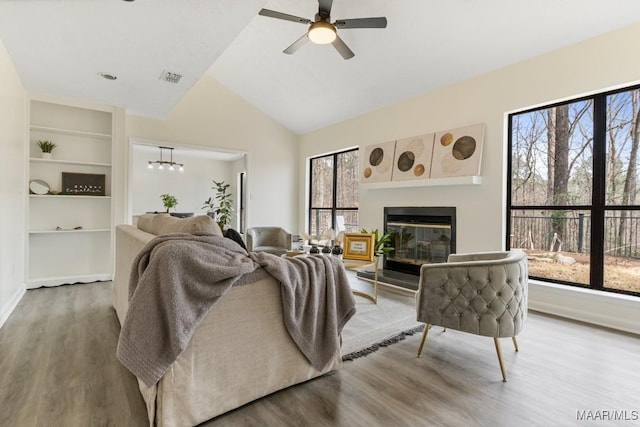 living room with ceiling fan, hardwood / wood-style flooring, lofted ceiling, and built in features