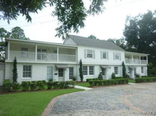 view of front of property with a front yard and a balcony