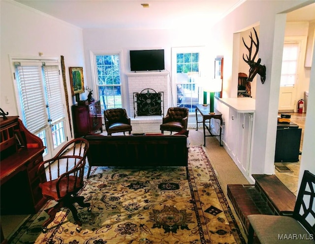 living room featuring a brick fireplace, crown molding, and a wealth of natural light