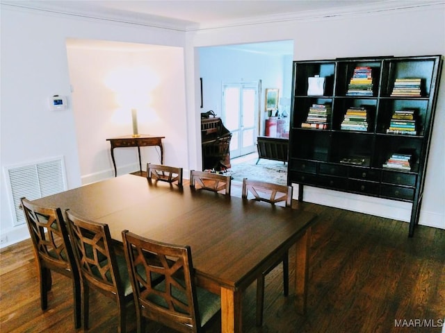 dining space with hardwood / wood-style floors and crown molding