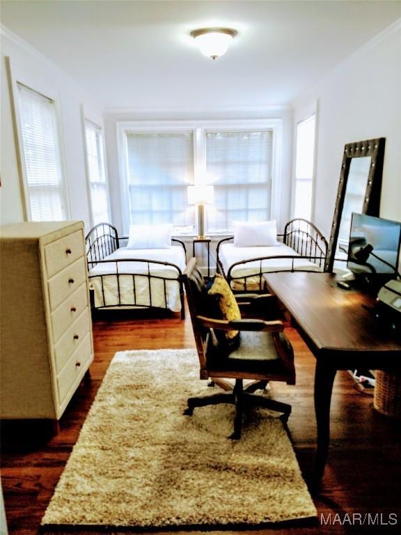 bedroom featuring ornamental molding and dark wood-type flooring