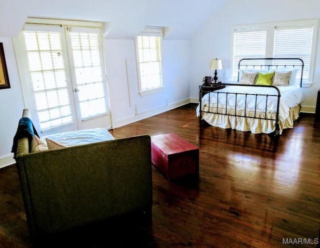 bedroom with dark wood-type flooring and lofted ceiling