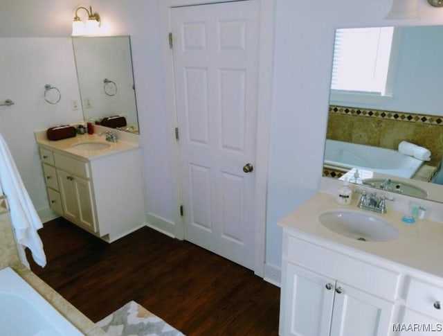 bathroom featuring a tub to relax in, vanity, and hardwood / wood-style flooring