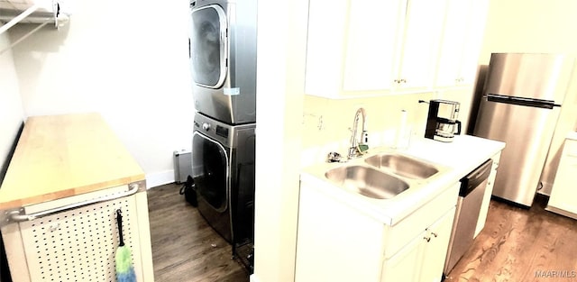 washroom with sink, dark wood-type flooring, and stacked washer / drying machine