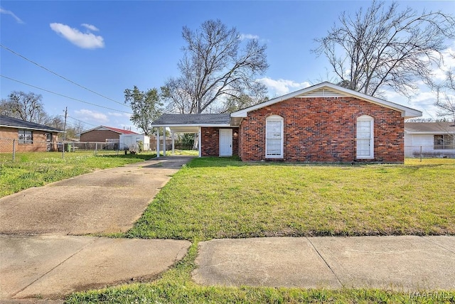 ranch-style house with an attached carport, a front yard, fence, driveway, and brick siding