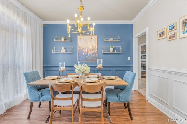 dining space featuring ornamental molding, a chandelier, and hardwood / wood-style floors