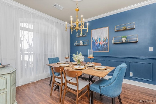 dining room featuring a chandelier, wood-type flooring, and ornamental molding