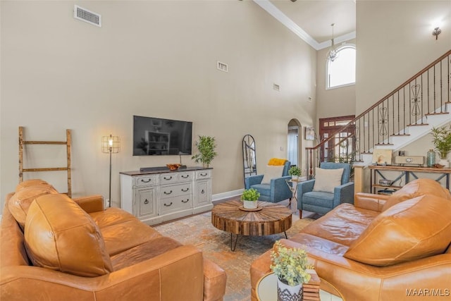 living room featuring ornamental molding and a towering ceiling