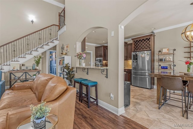 living room featuring ornamental molding, a towering ceiling, and an inviting chandelier