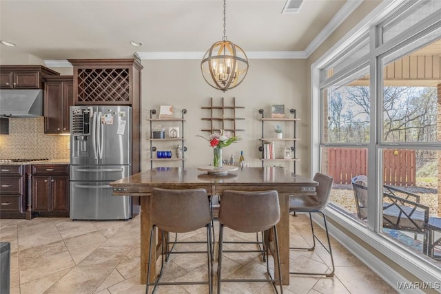 dining space featuring crown molding and a notable chandelier