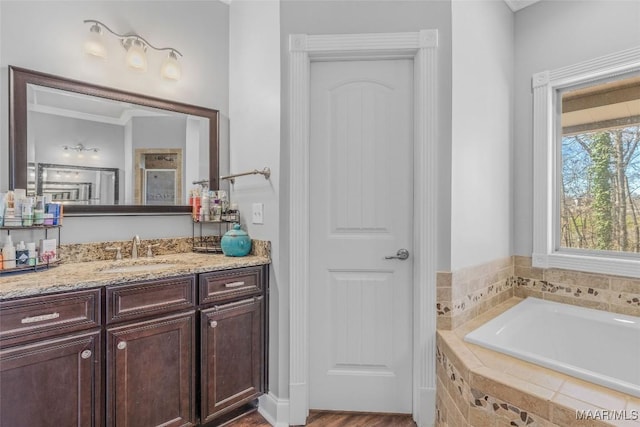 bathroom featuring vanity and tiled tub