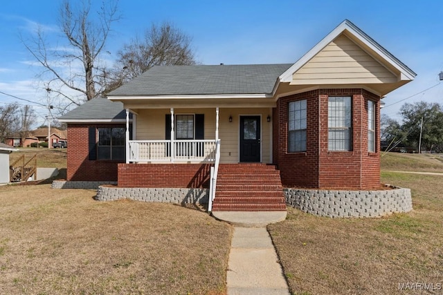 bungalow-style house featuring covered porch and a front yard