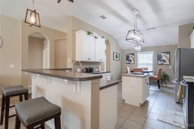 kitchen with a kitchen bar, pendant lighting, white cabinetry, and a kitchen island