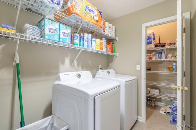 laundry room with light tile patterned flooring and washing machine and clothes dryer