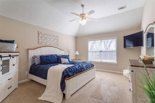 bedroom with ceiling fan, a textured ceiling, light colored carpet, and lofted ceiling