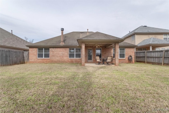 rear view of property featuring a yard, a patio, and ceiling fan