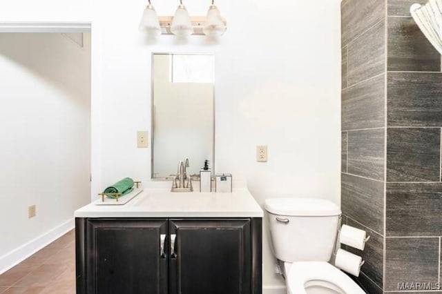 bathroom featuring toilet, vanity, tile patterned flooring, and an inviting chandelier