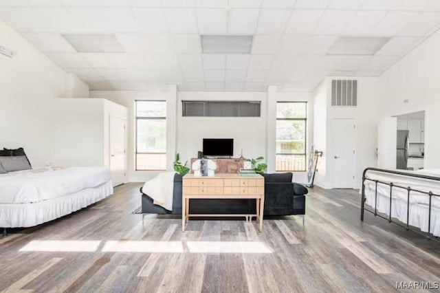 living room featuring a paneled ceiling, plenty of natural light, and wood-type flooring
