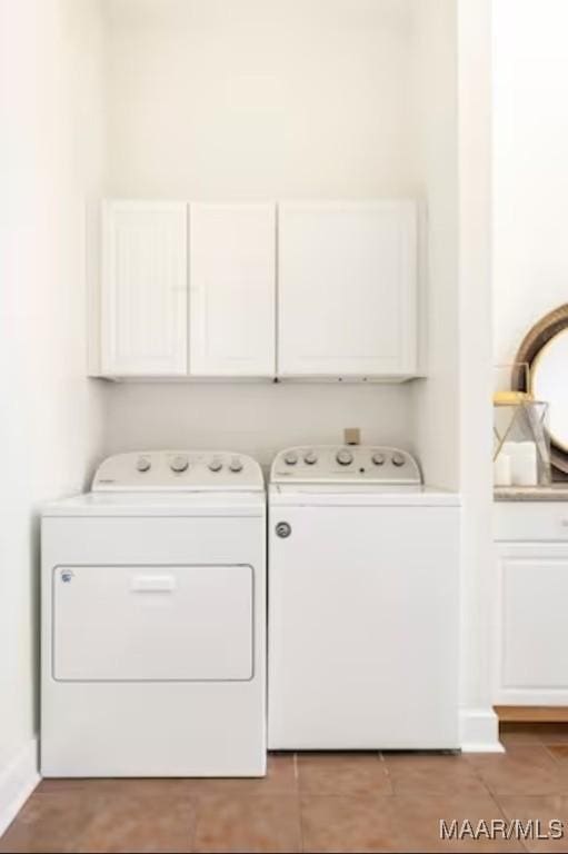 clothes washing area featuring independent washer and dryer and cabinets