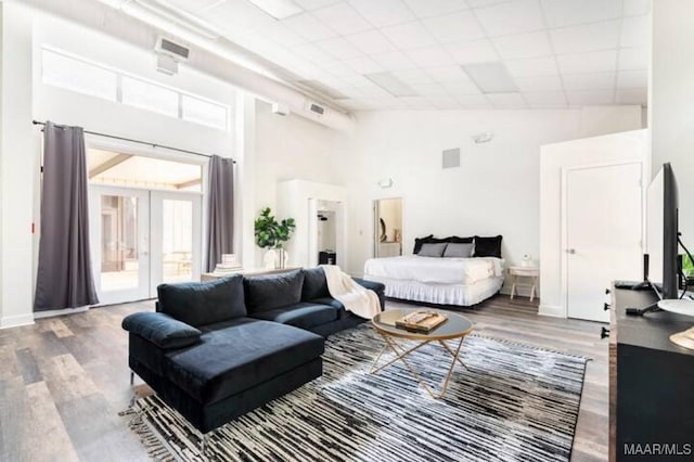 bedroom with high vaulted ceiling, french doors, and wood-type flooring