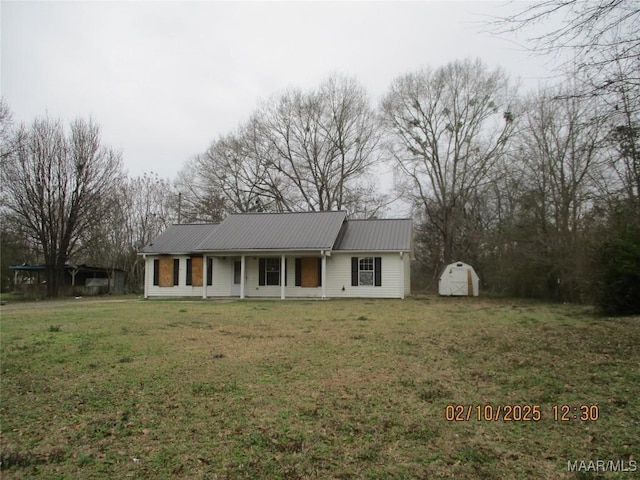 view of front of home with metal roof and a front lawn