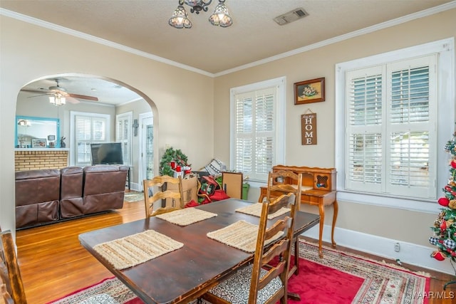 dining space featuring a textured ceiling, hardwood / wood-style flooring, crown molding, and ceiling fan