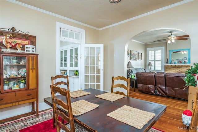 dining area with a textured ceiling, ornamental molding, hardwood / wood-style flooring, and ceiling fan