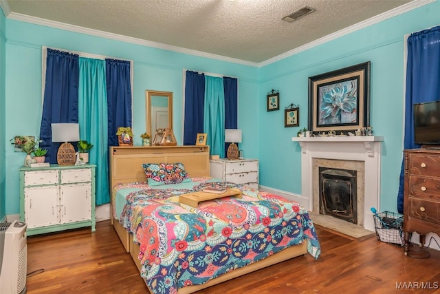 bedroom featuring a textured ceiling, crown molding, and dark hardwood / wood-style floors