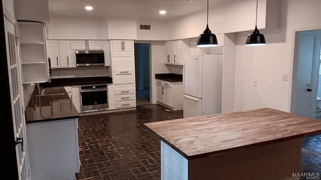 kitchen featuring white cabinetry, appliances with stainless steel finishes, and pendant lighting