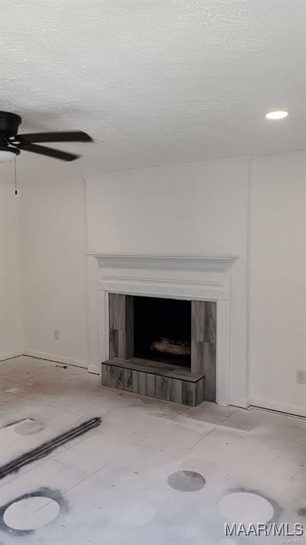 details with ceiling fan, a textured ceiling, and a fireplace