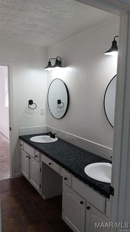 bathroom with a textured ceiling, vanity, and tile patterned floors