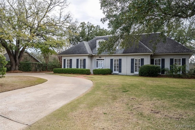 view of front of home featuring roof with shingles and a front lawn