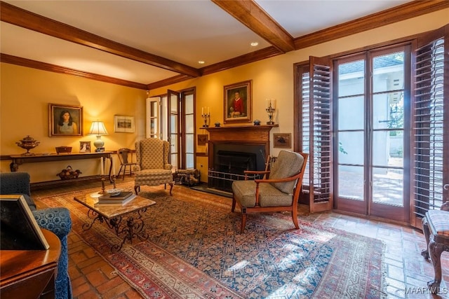 living area featuring a healthy amount of sunlight, ornamental molding, and beamed ceiling