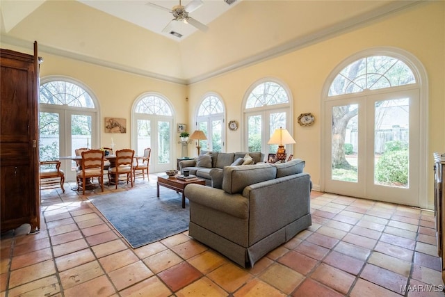 living area with a ceiling fan, a towering ceiling, and french doors