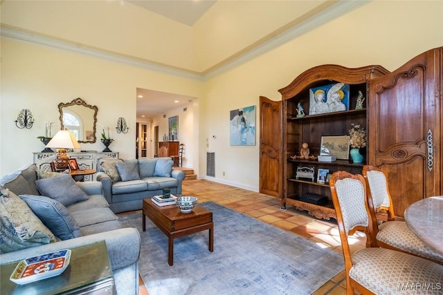 living area with baseboards, ornamental molding, visible vents, and light tile patterned floors