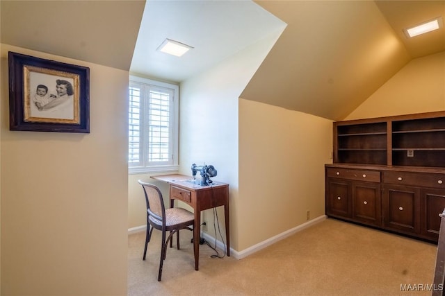 office area with baseboards, vaulted ceiling, and light carpet