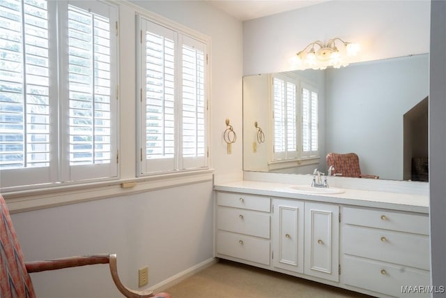 bathroom featuring plenty of natural light, vanity, and baseboards