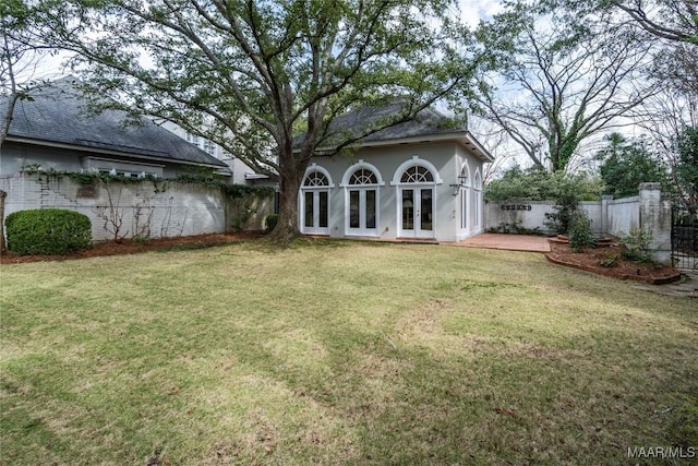 view of yard with french doors and a fenced backyard