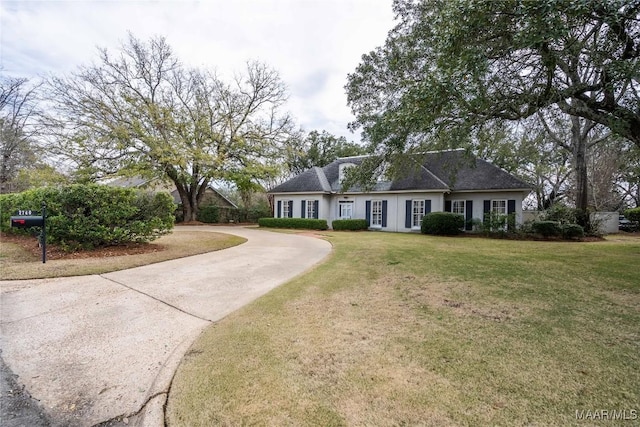 view of front of house with concrete driveway and a front yard