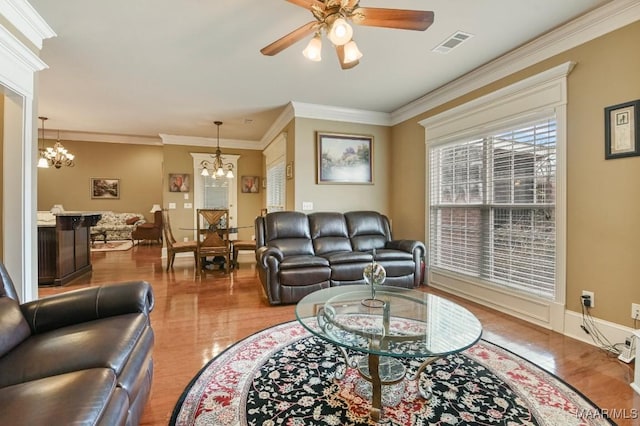 living room with wood finished floors, a chandelier, a ceiling fan, and ornamental molding